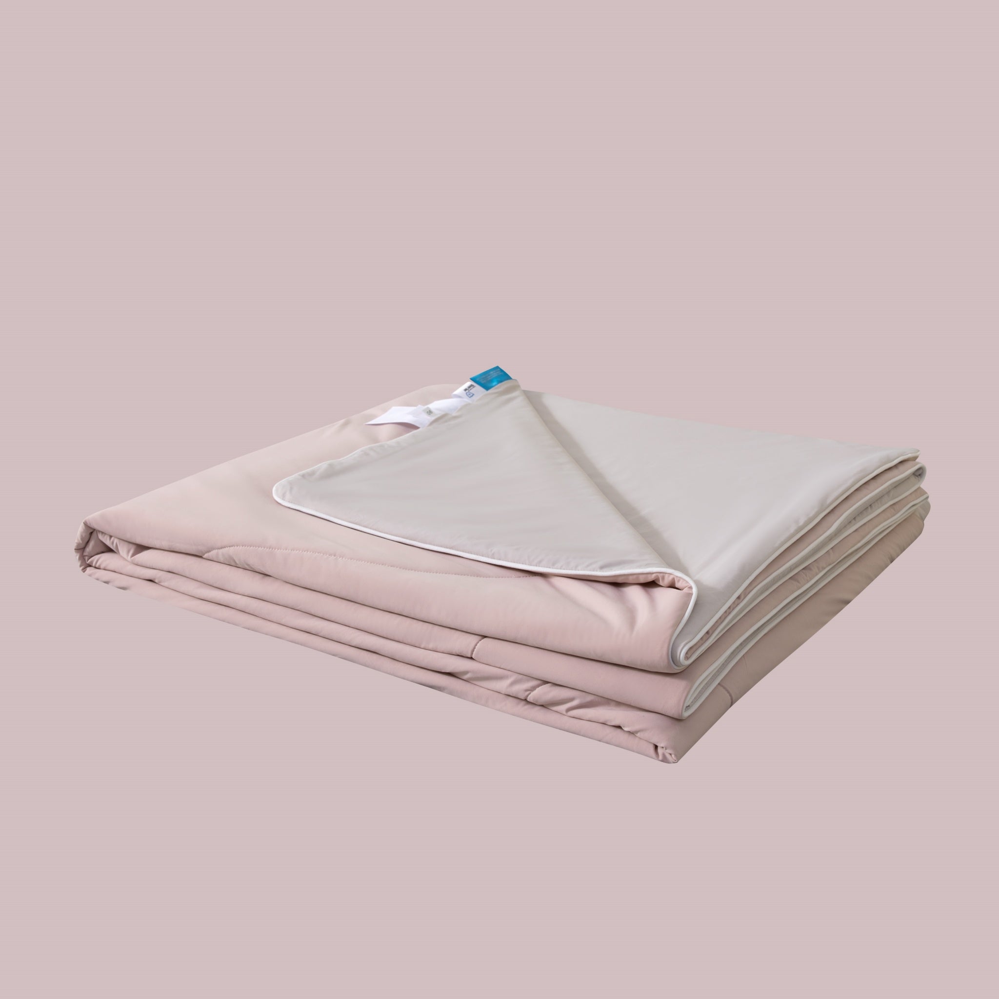Folded pink blanket with a white label on a beige background
