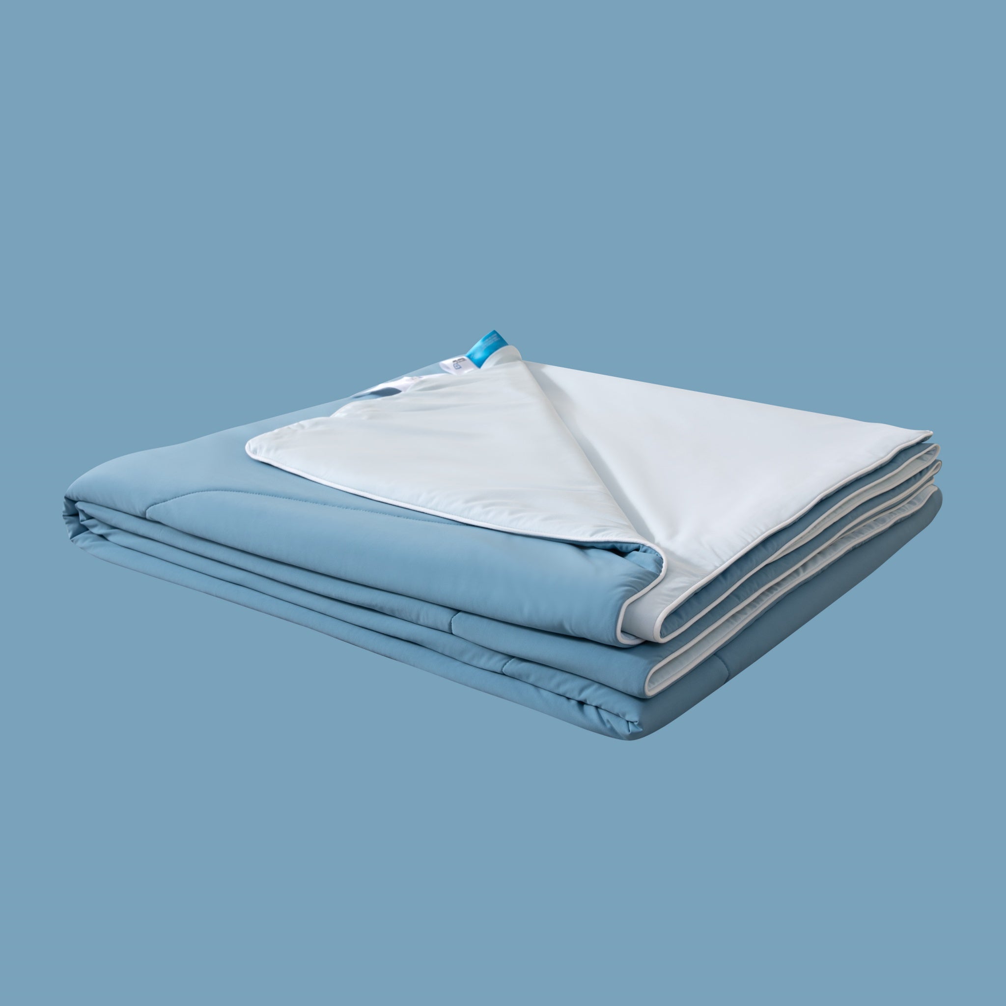 Folded blue and white blanket on a light blue background