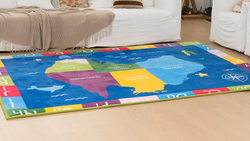 Colorful United States map rug in a living room with a white couch and fireplace.