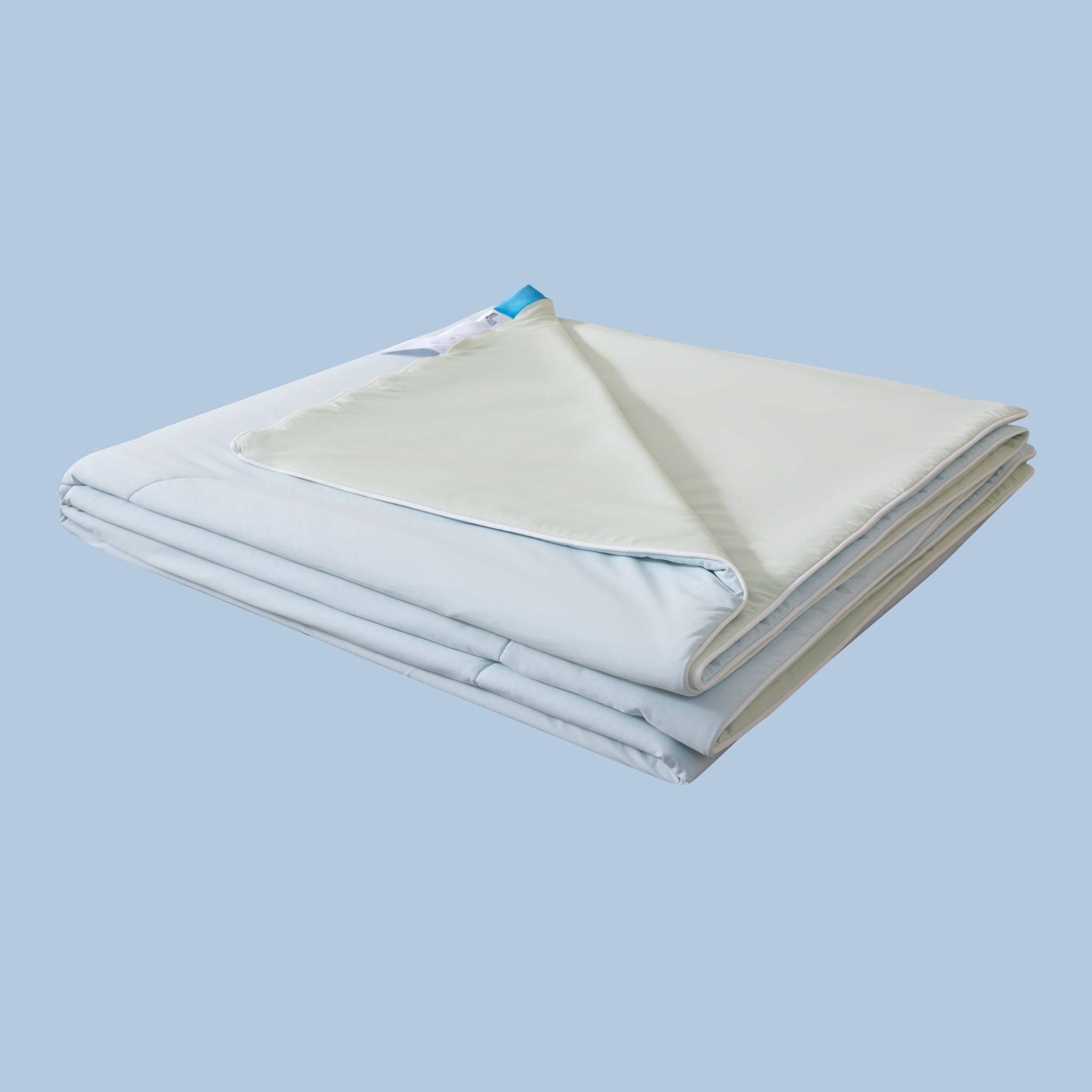 Folded bed sheets on a light blue background