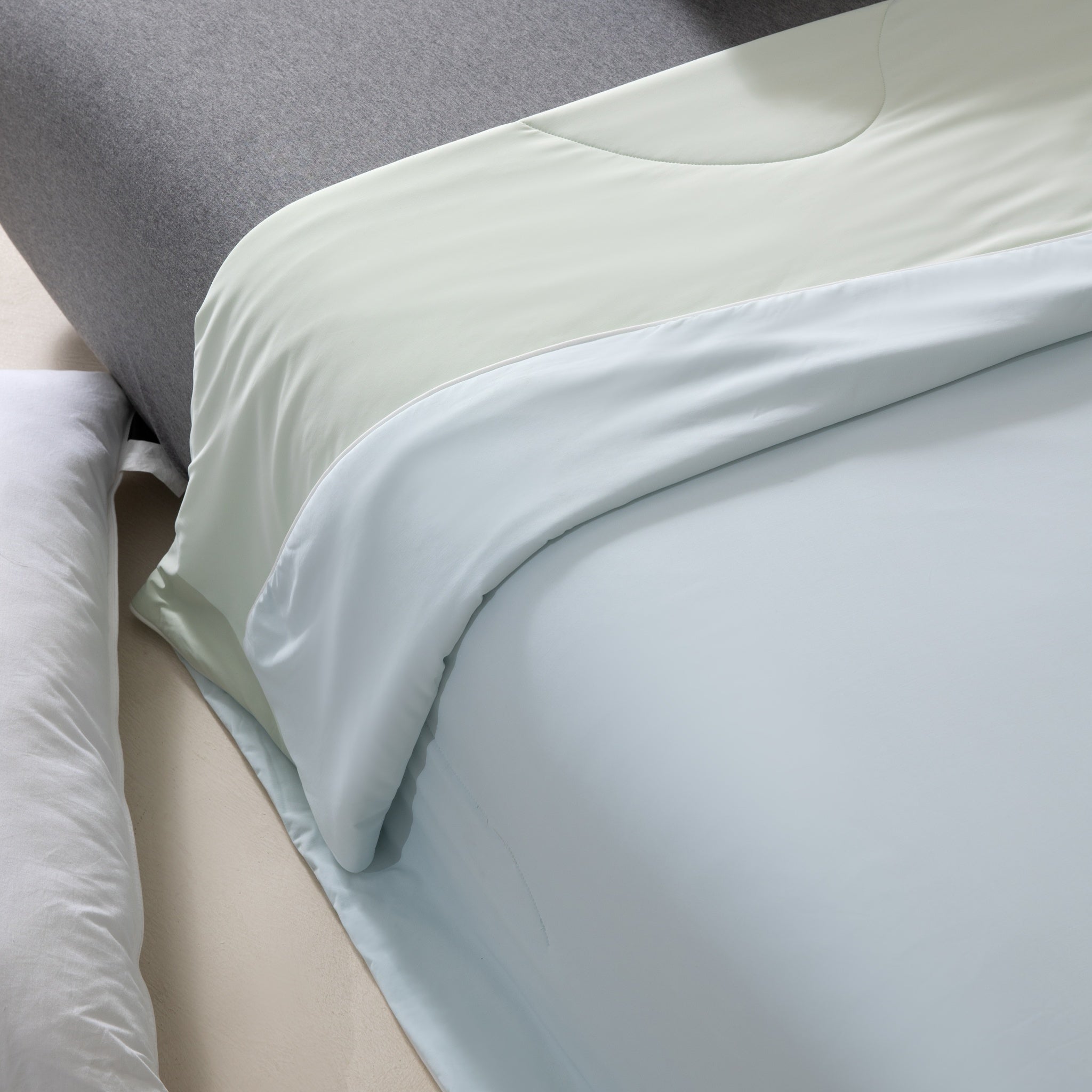 Light blue fitted sheet on a bed with pillows