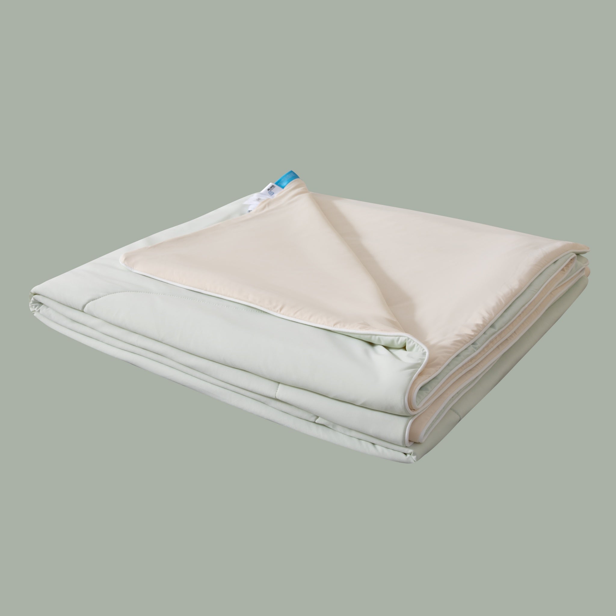 Folded blanket with a visible brand label on a light gray background