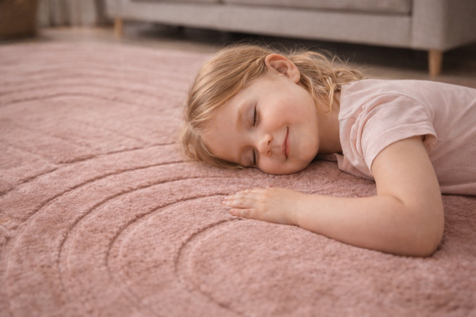 Young girl lying on a pink carpeted floor