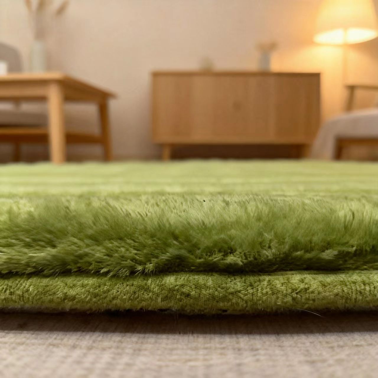 Green rug in a room with wooden furniture and a lamp.
