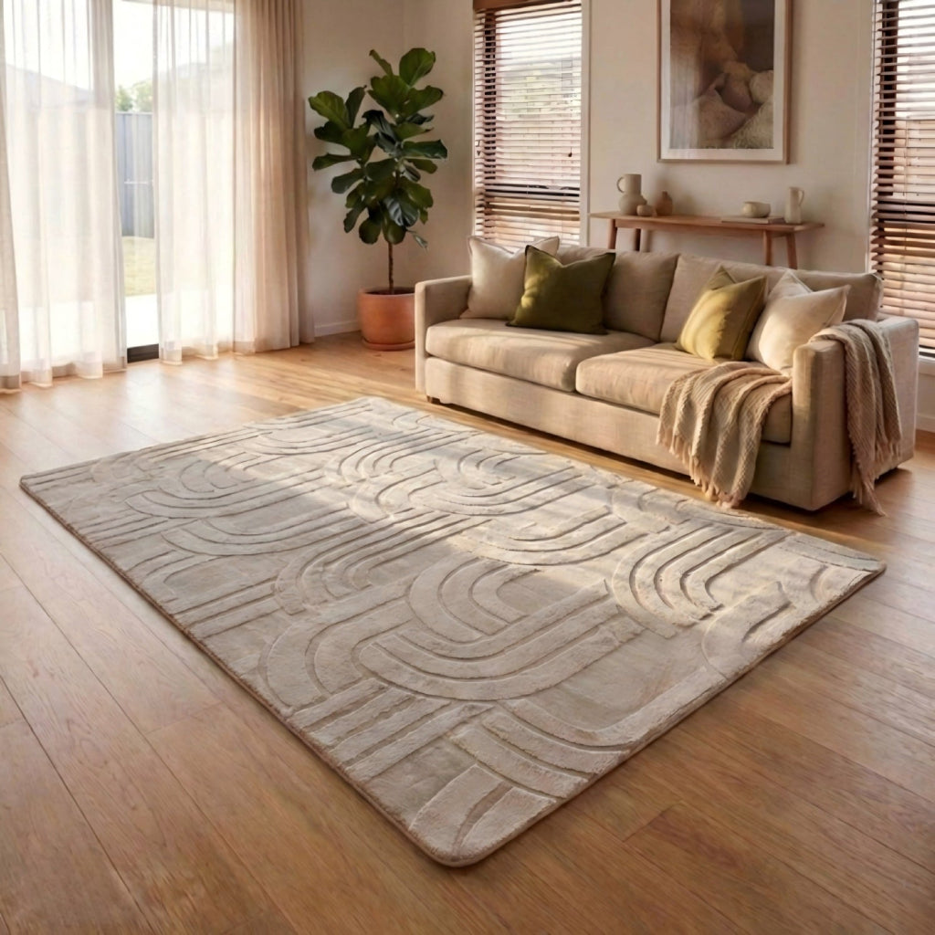 Living room with a beige sofa, patterned rug, and decorative elements.