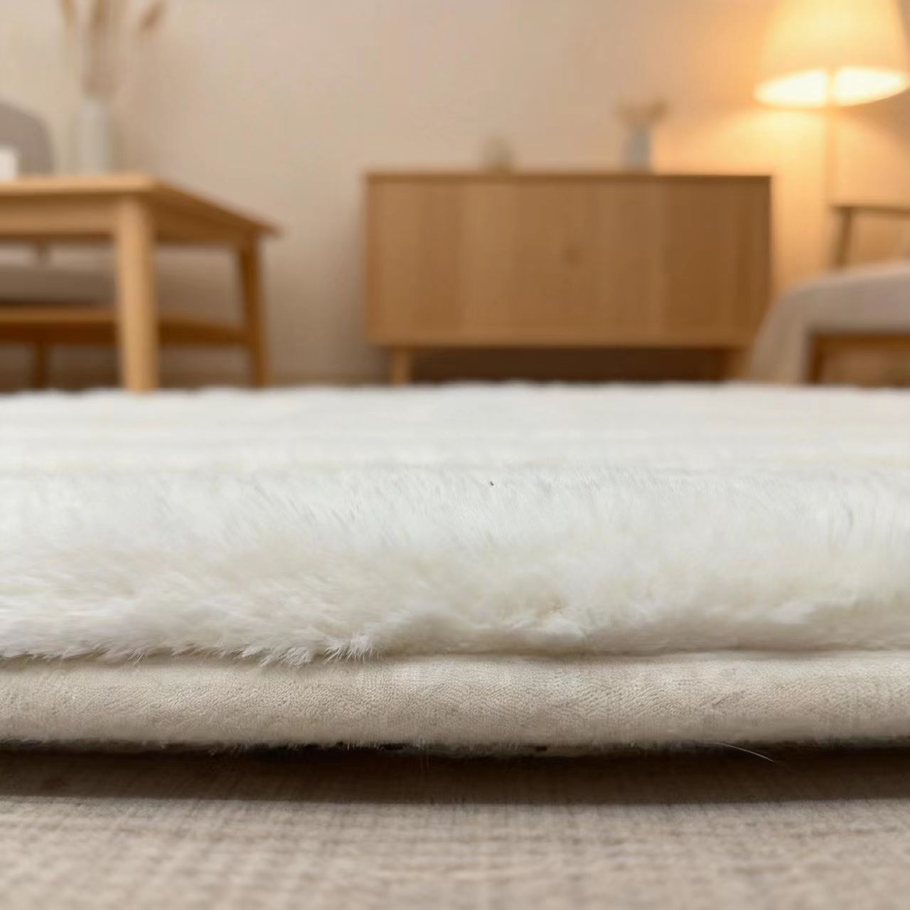 Close-up of a white mattress pad with a blurred bedroom background