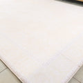 Beige bath mat on a tiled floor