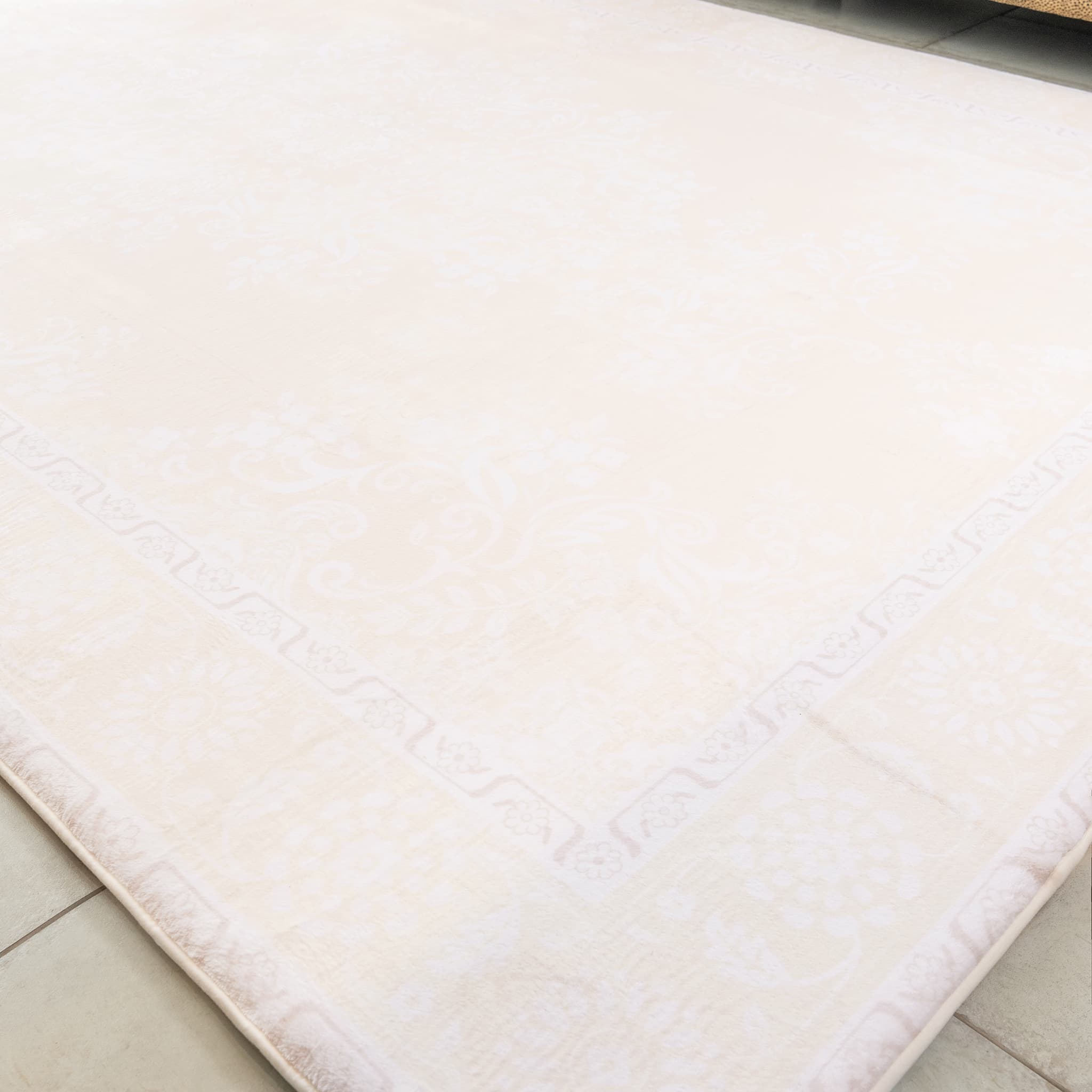 Beige bath mat on a tiled floor