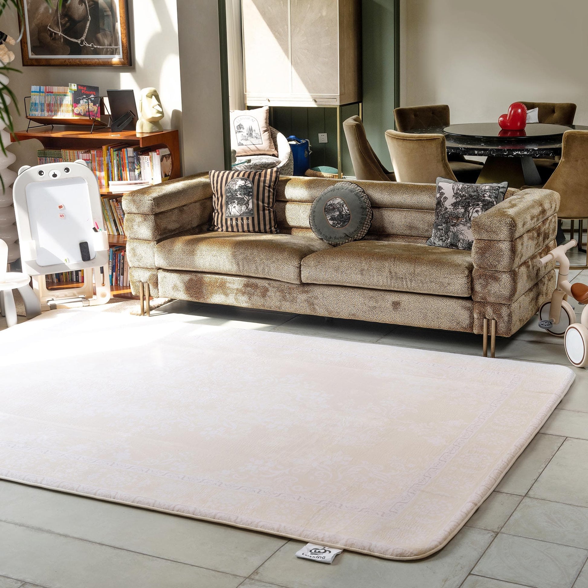 Beige sofa with decorative pillows on a white rug in a living room setting.