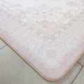 Patterned pink bath mat on a tiled floor