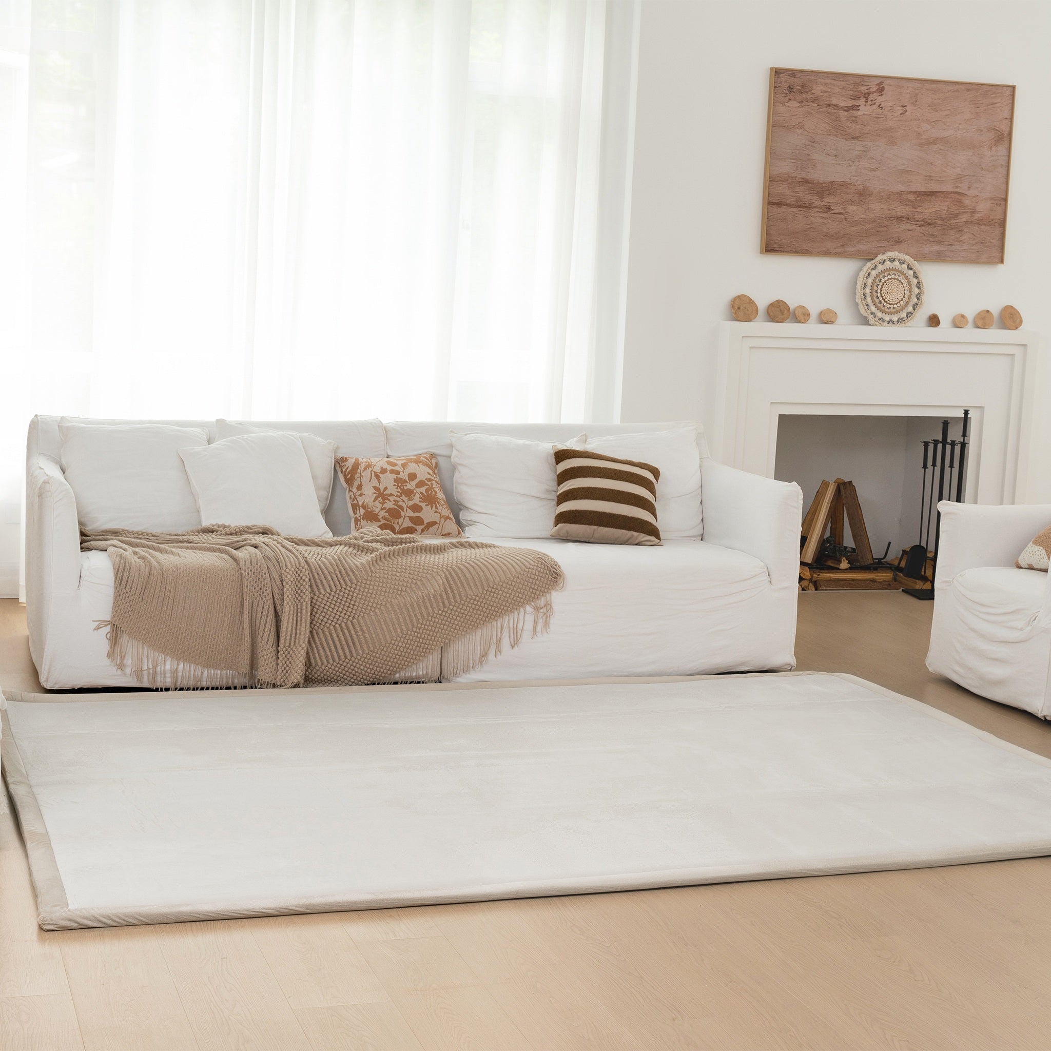 White sofa with decorative pillows and a blanket in a living room setting.