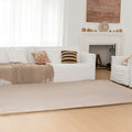 Living room with a white sofa, beige rug, and decorative elements.