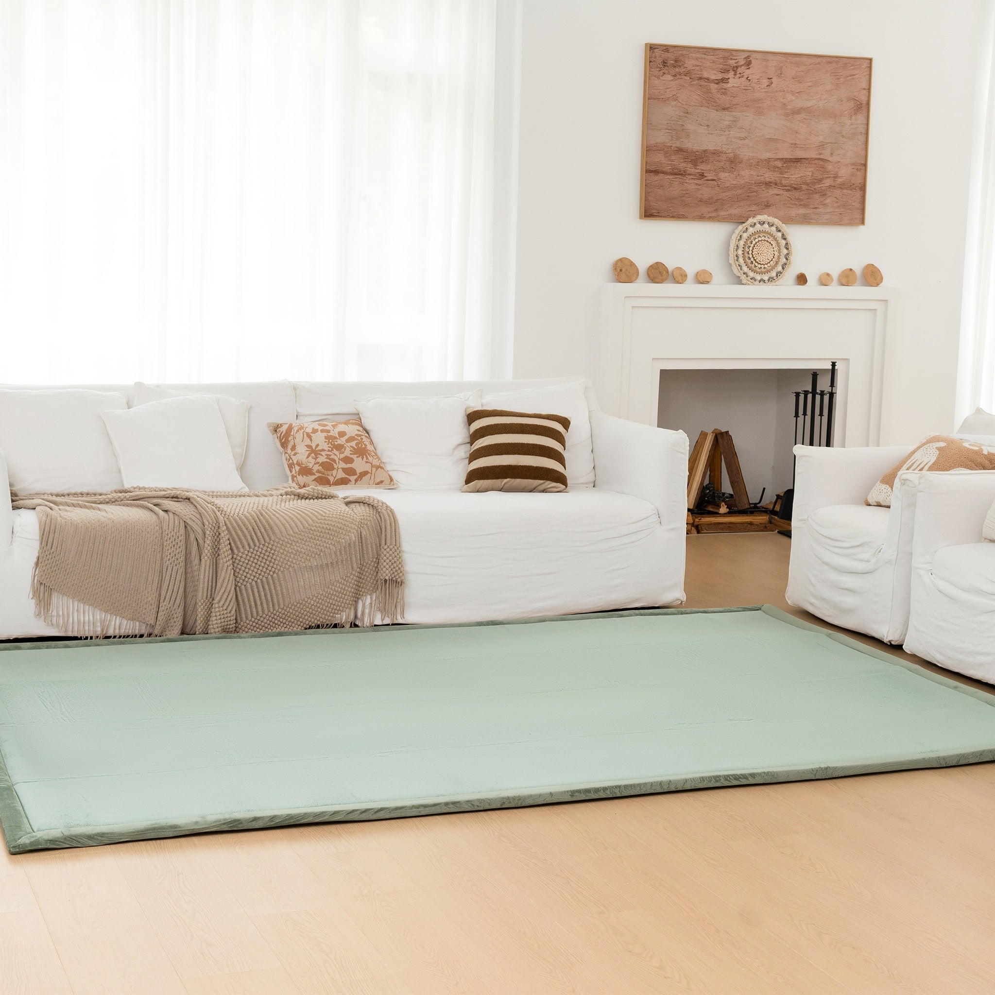 Living room with a green rug, white sofa, and decorative items.