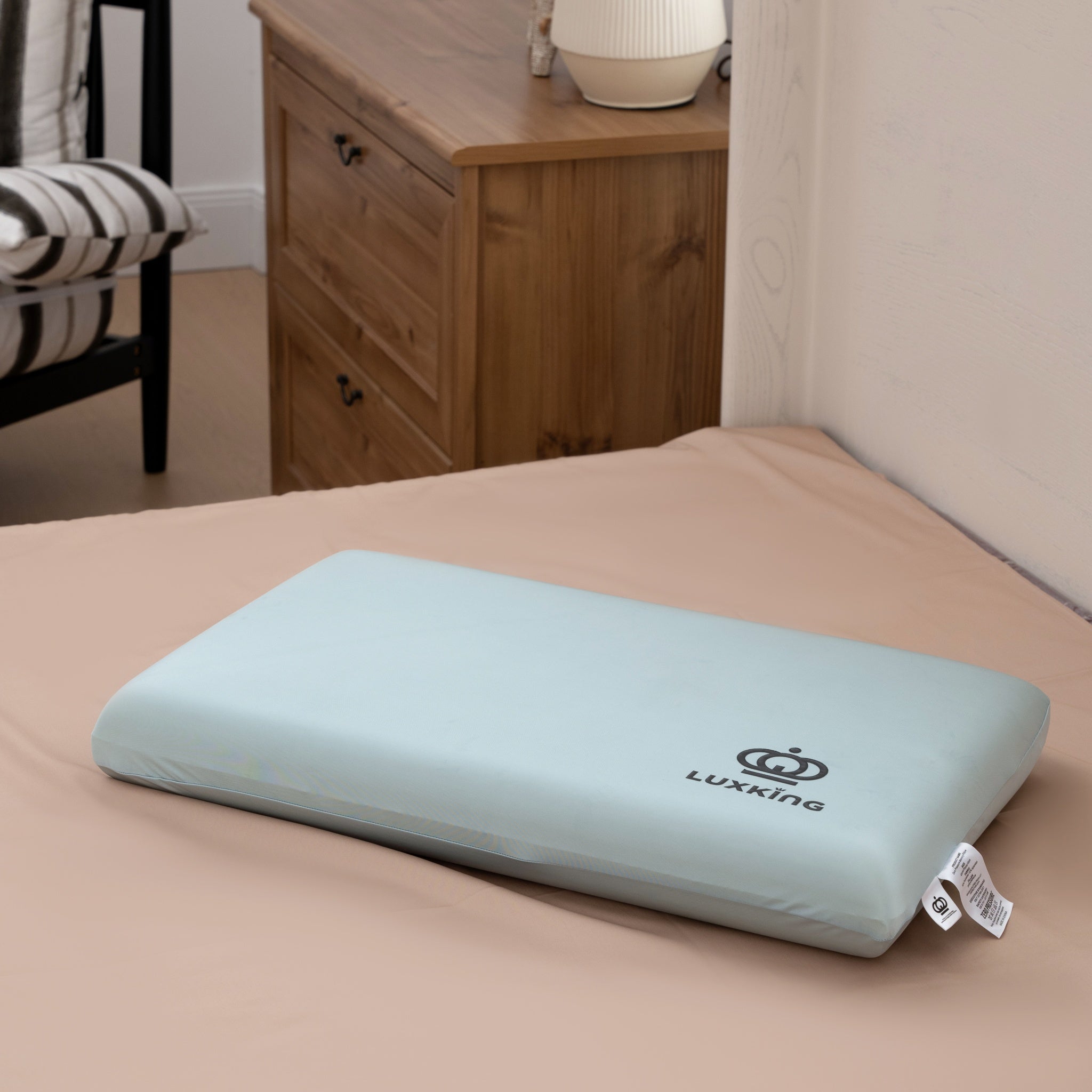 Light blue pillow with Luxking logo on a bed in a bedroom setting