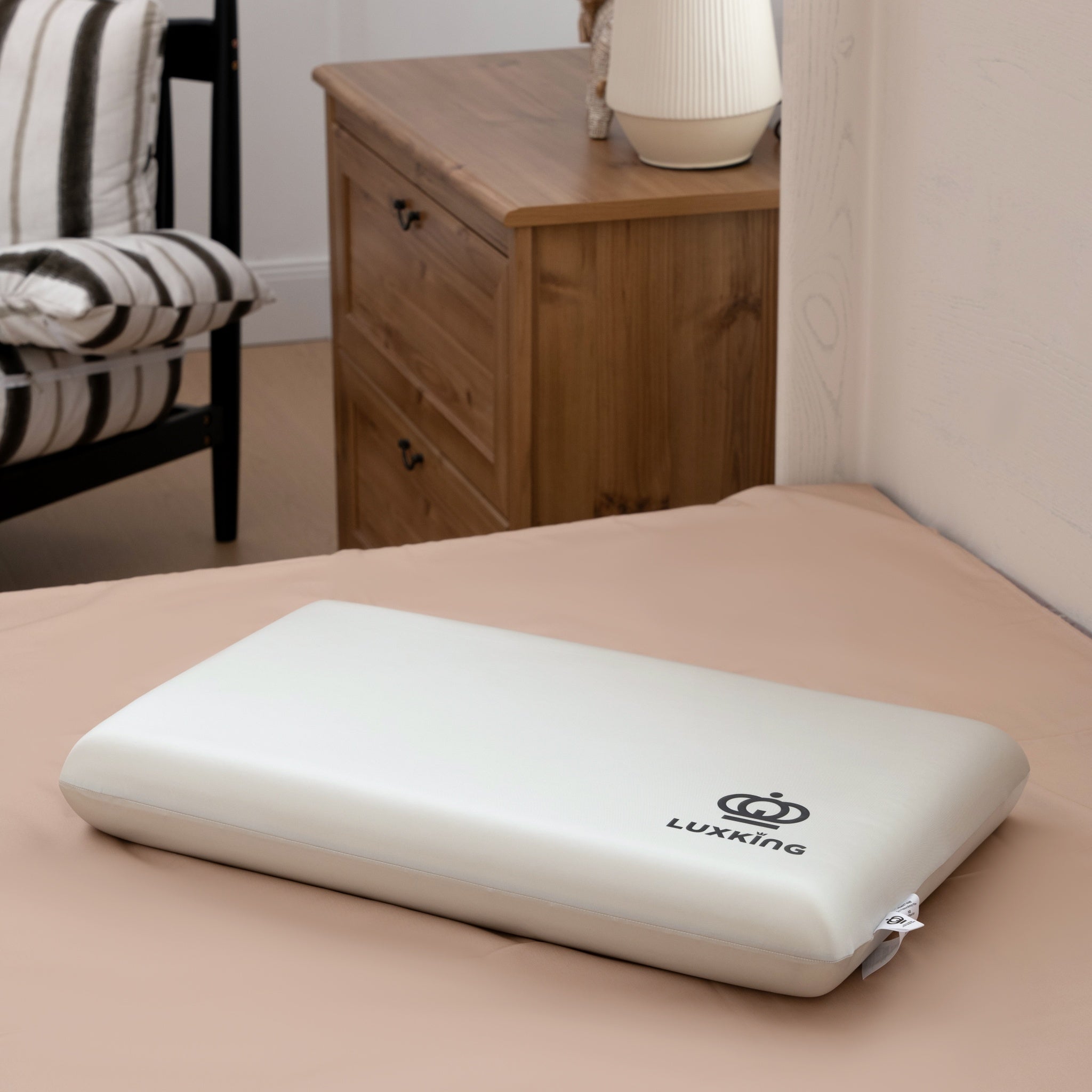 White pillow with 'Luxking' logo on a bed in a bedroom setting