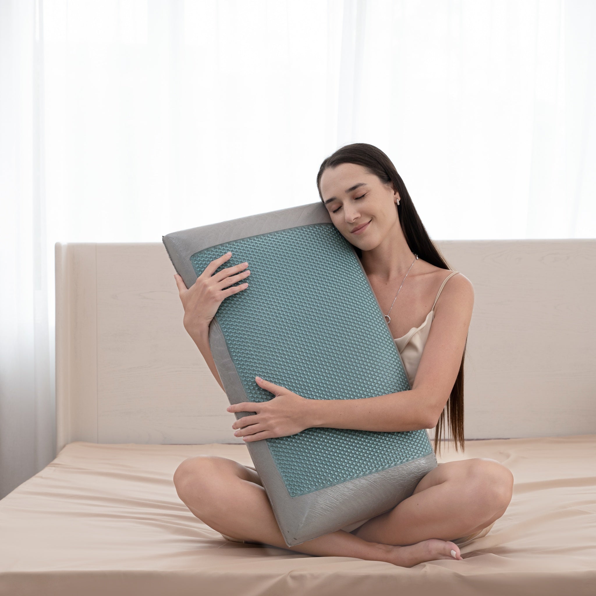 Woman holding a large, textured pillow on a bed