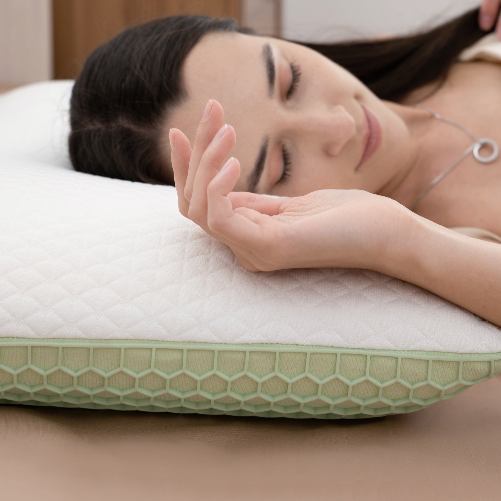 Woman lying on a green and white honeycomb-patterned pillow