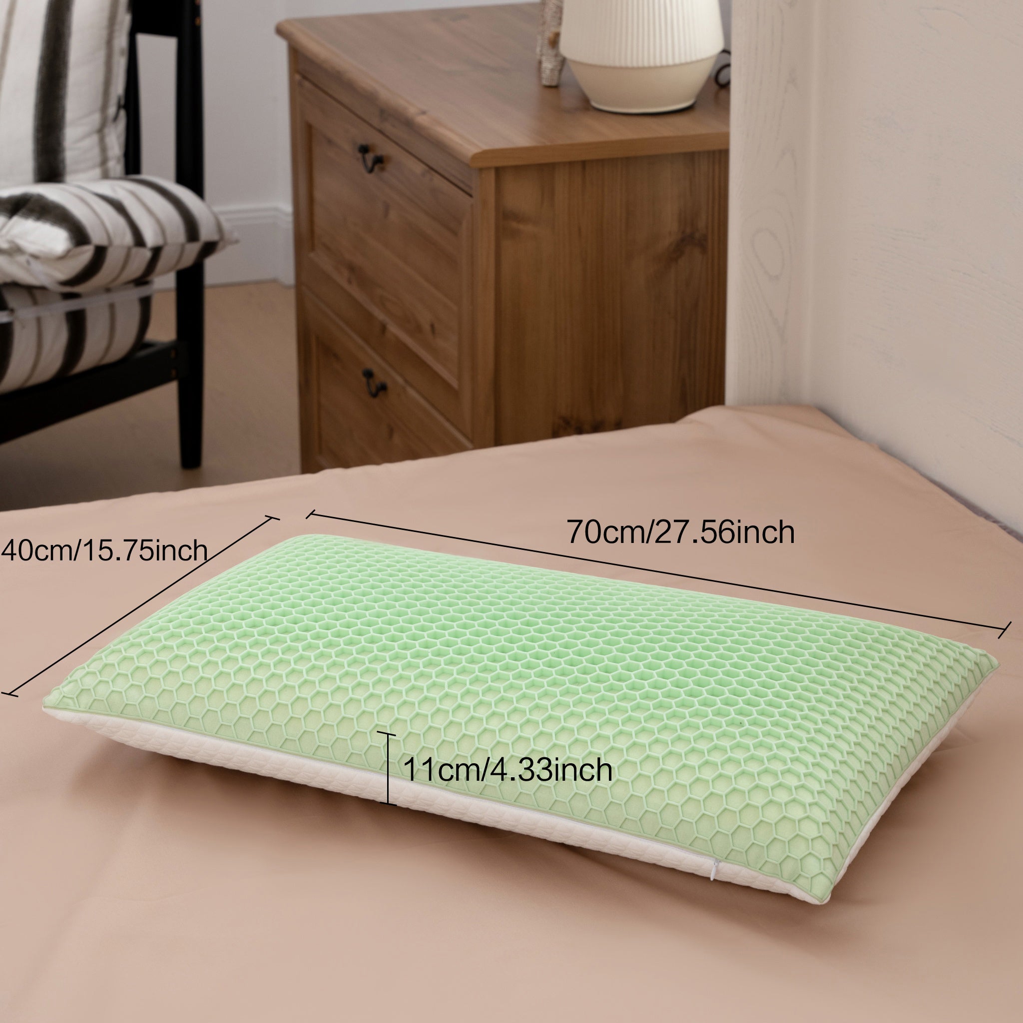 Green pillow with measurements on a bed in a bedroom setting