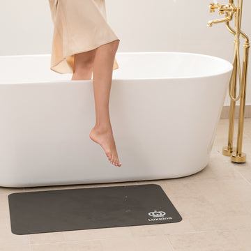 LuxKing Bath Mat on the Tiled Floor Model is out of the bathtub with the water dripping down from the leg