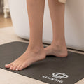 Person standing on a black mat with 'LUXKING' branding in a home setting.