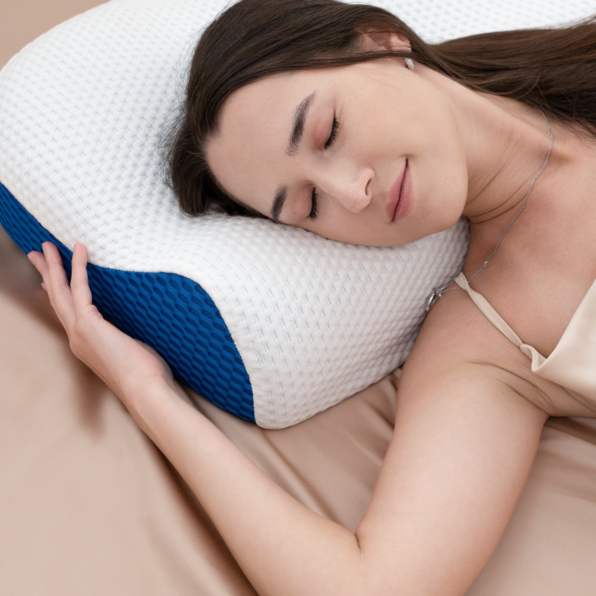 Woman sleeping on a white pillow with blue accents