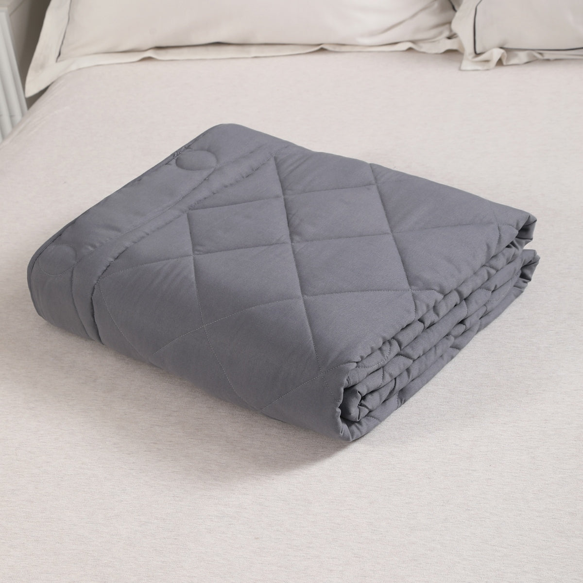 Folded gray weighted blanket on a bed