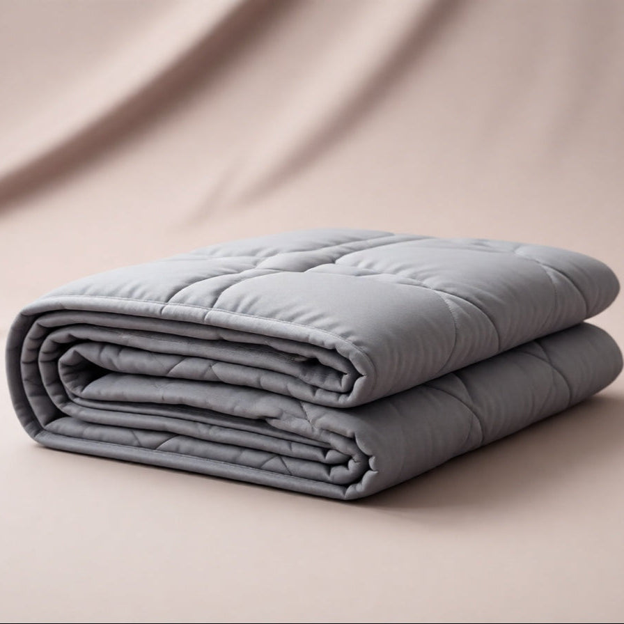 Folded gray comforter on a beige surface