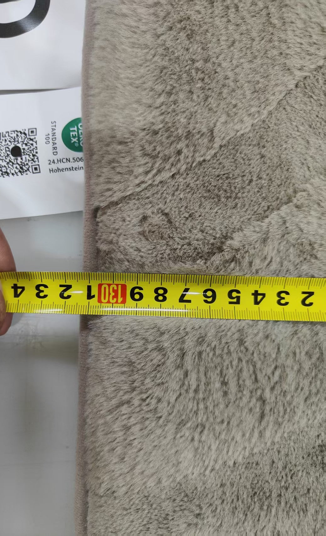 Textured fabric with a measuring tape indicating dimensions