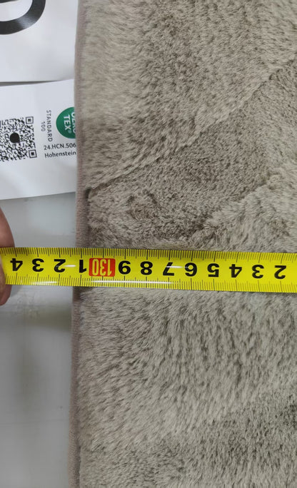 Textured fabric with a measuring tape indicating dimensions