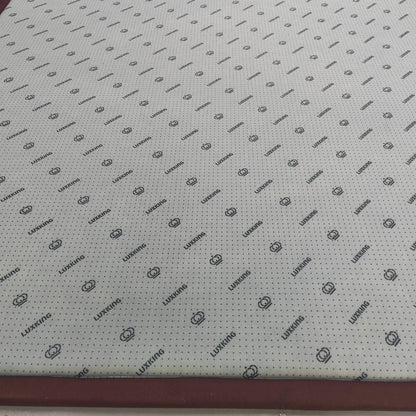 Sheet of material with a grid pattern and brand logo on a flat surface
