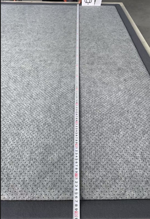 Gray textured material with a measuring tape for scale on a gray background