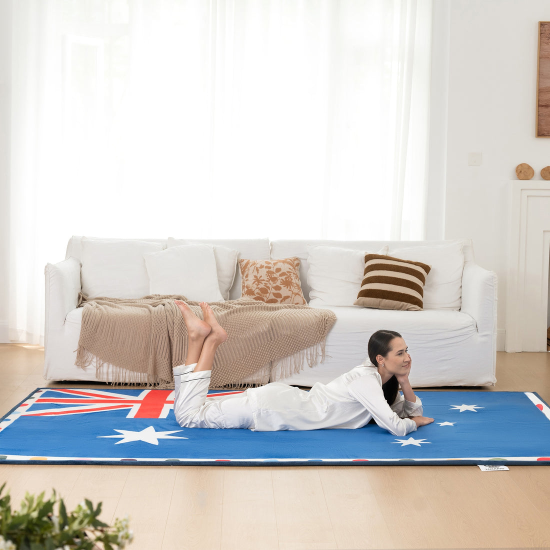 Woman lying on a blue mat with white star patterns in a living room.