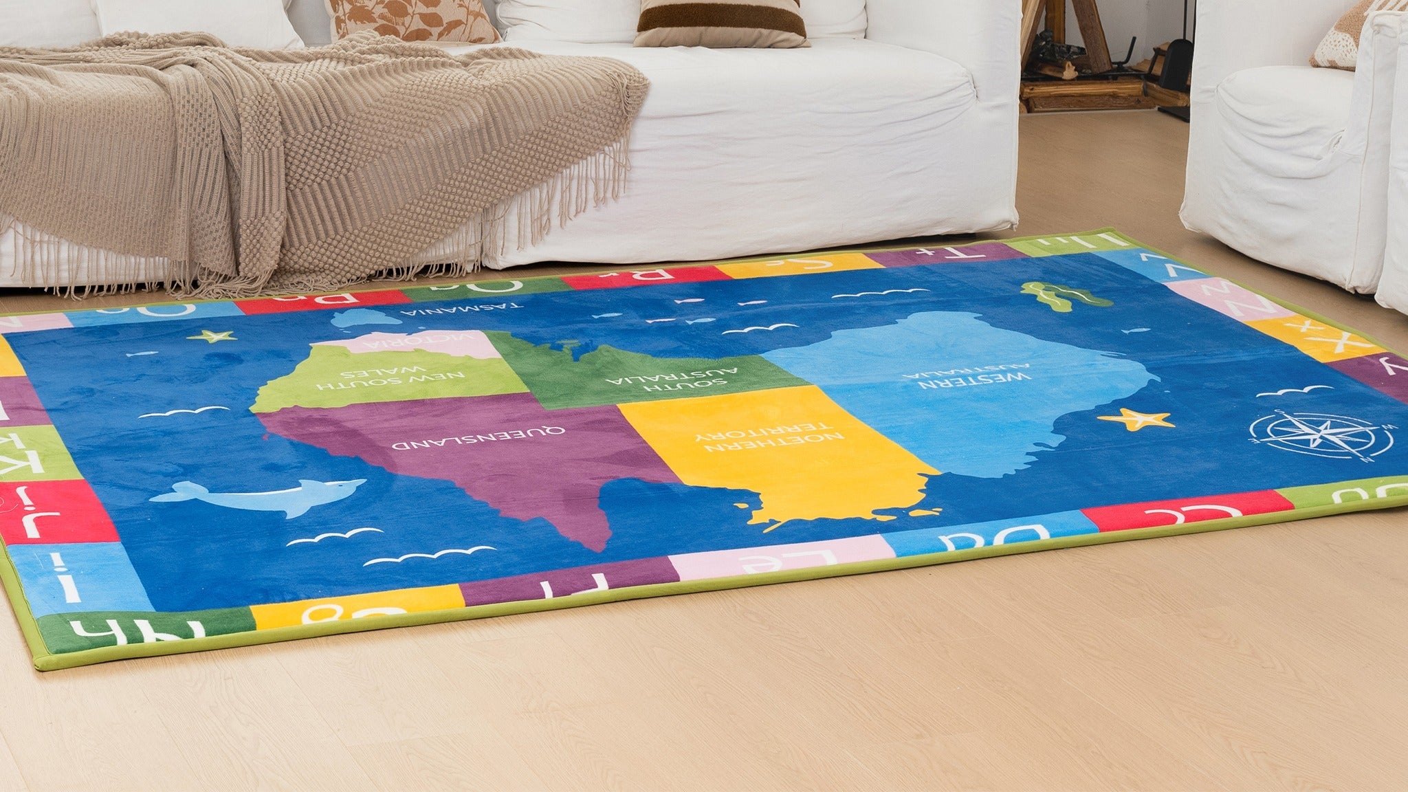 Colorful United States map rug in a living room with a white couch and fireplace.