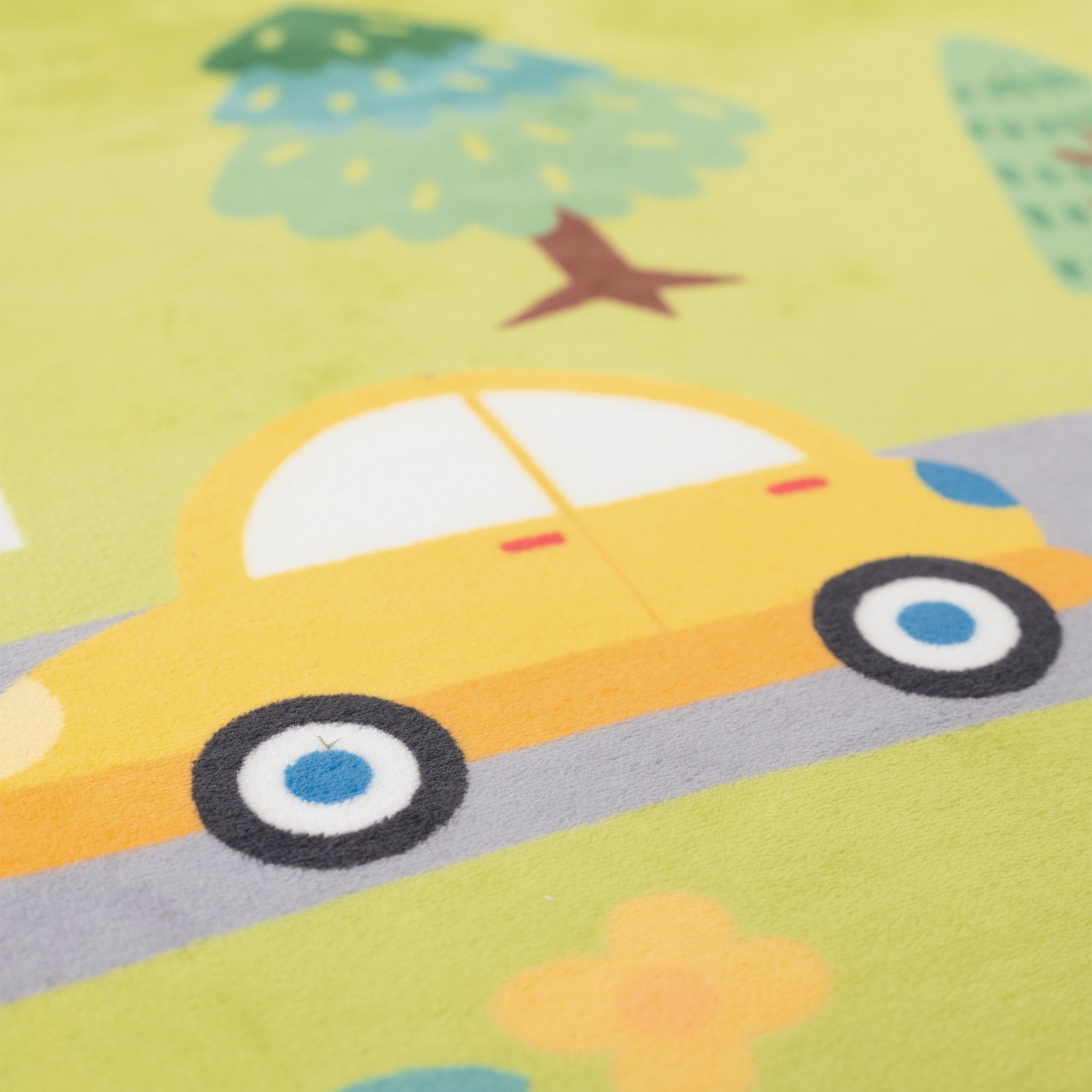 Children's play mat with a yellow car and green trees on a yellow background