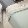 Close-up of a bed with light-colored bedding and pillows.
