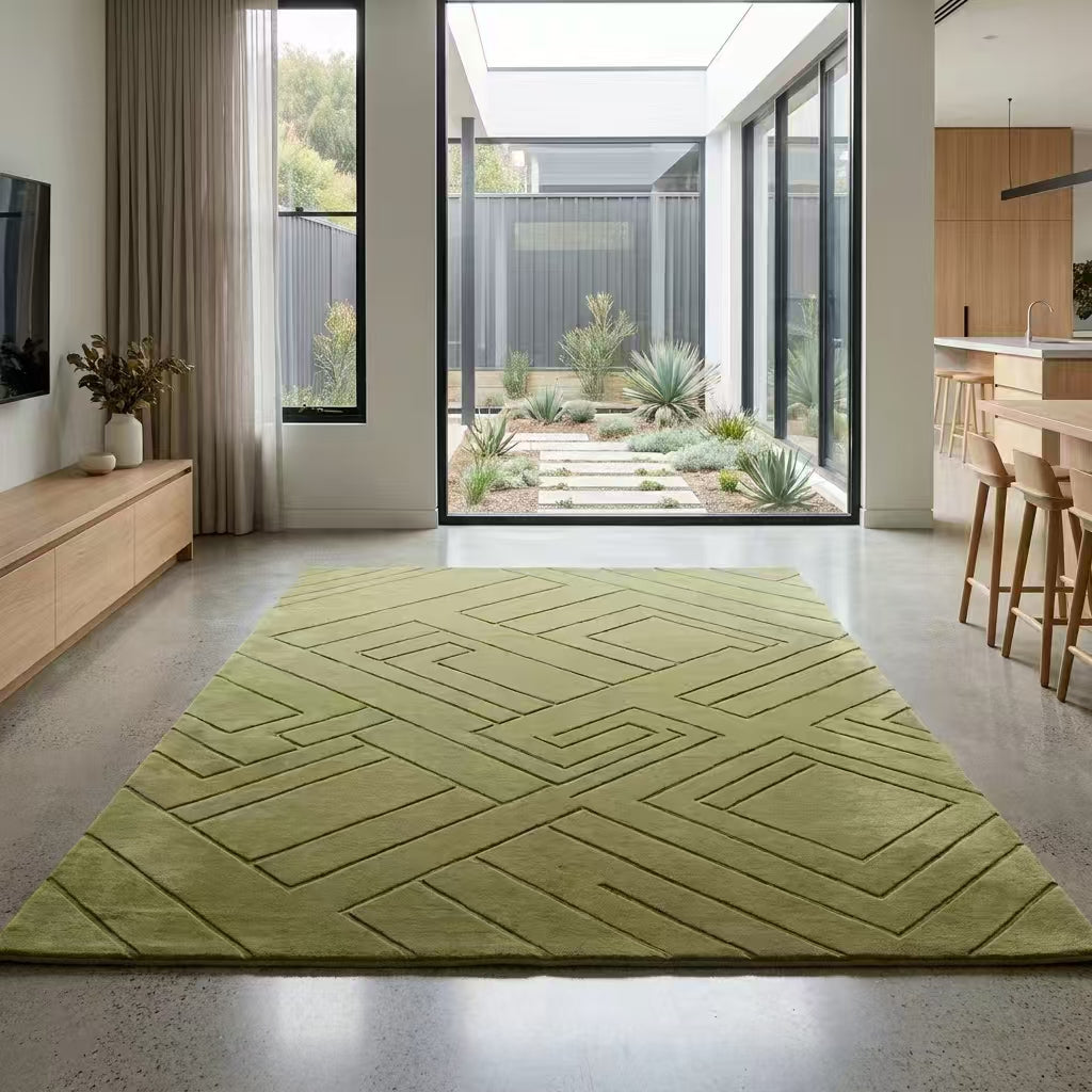 Green geometric rug in a modern living room with large windows.