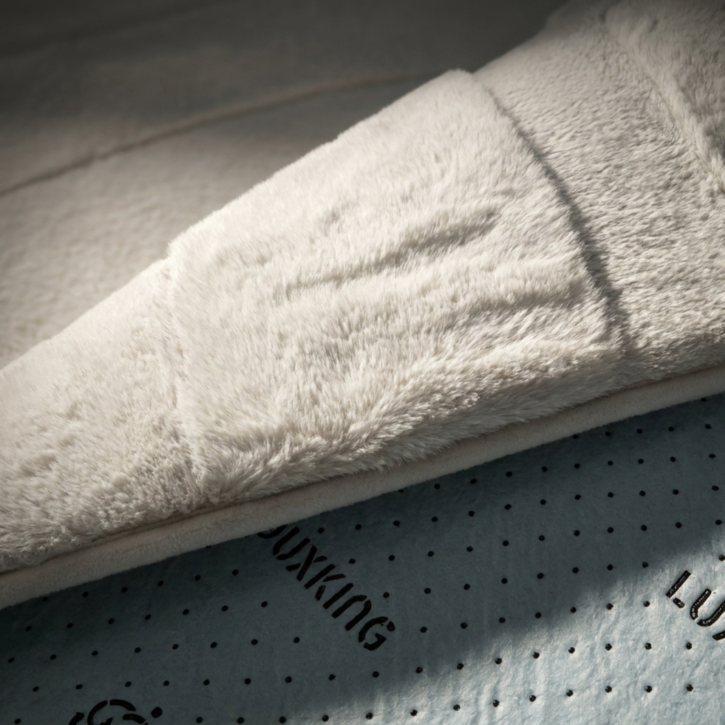 Close-up of a textured white fabric on a perforated surface with 'Luxking' branding.