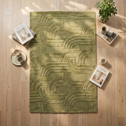 Green textured rug on a wooden floor with decor items around