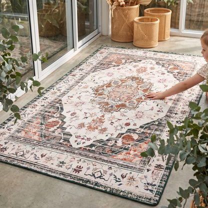 A children's play rug with a city road and hospital theme, shown in a split-screen view. The left panel shows a wider view of the rug in a bright playroom with potted plants and toys, while the right panel is a close-up of the rug's details, including a police station and ambulance.