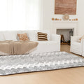 Living room with a patterned rug, a white sofa, and a fireplace.