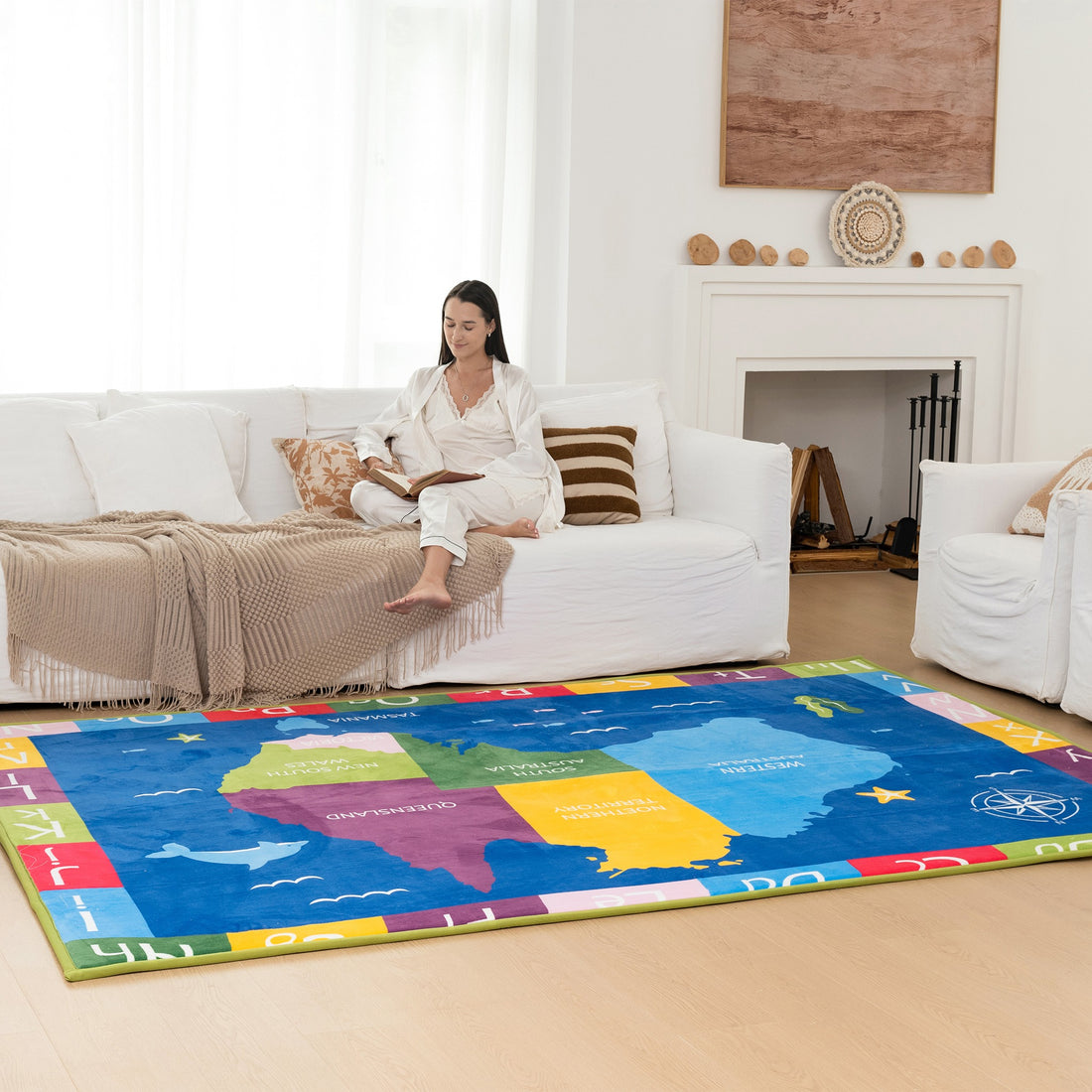 Woman sitting on a couch in a living room with a colorful Australia map rug.