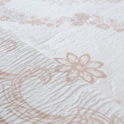 Close-up of textured fabric with floral patterns in beige on a white background