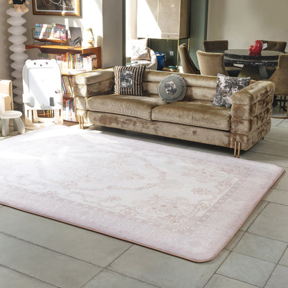 Beige sofa with decorative pillows on a light pink rug in a living room setting.