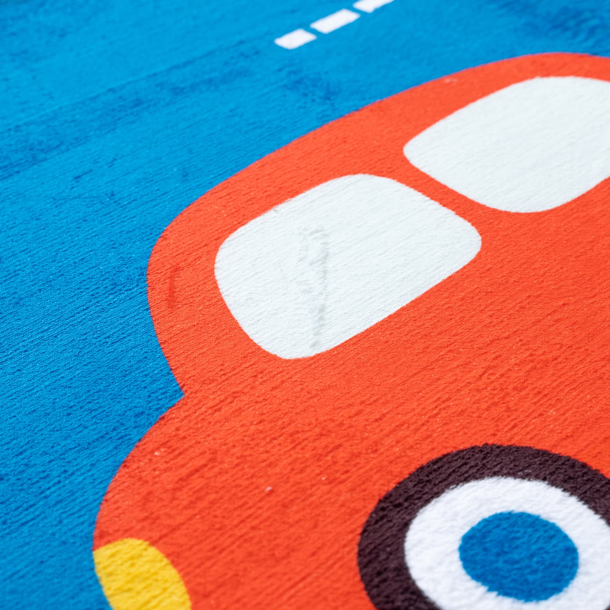 Close-up of a red car toy with white windows on a blue background