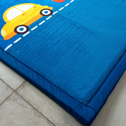 Blue LuxKing cloud mat with yellow car design on a tiled floor