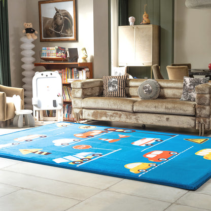 Children's room with a blue LuxKing Cloud rug featuring colorful car designs, a beige sofa, and toys.