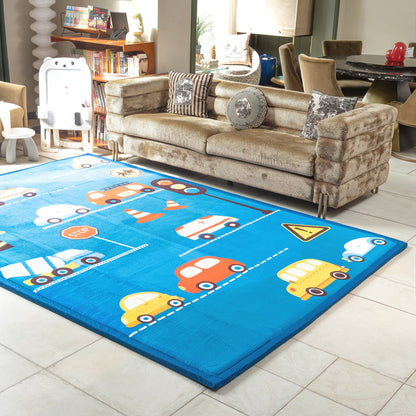 Children's playroom with a blue LuxKing Cloud Mat featuring colorful cars and traffic signs, a beige sofa, and a bookshelf