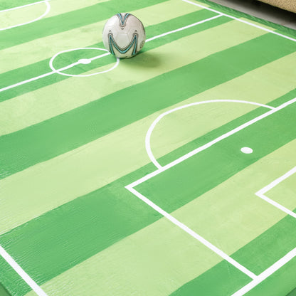 Soccer ball on a green sports-themed play mat with white lines