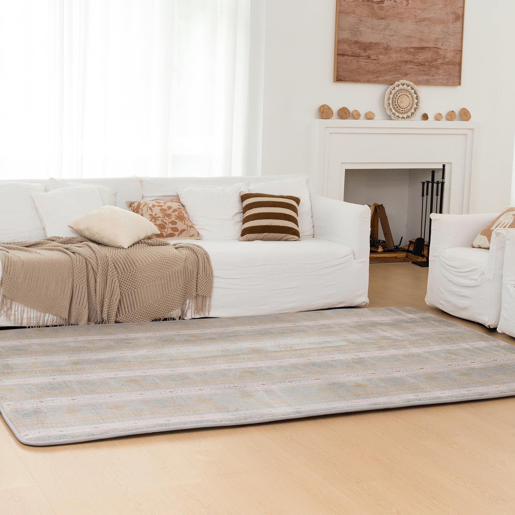 Living room with white sofa, beige rug, and decorative elements.