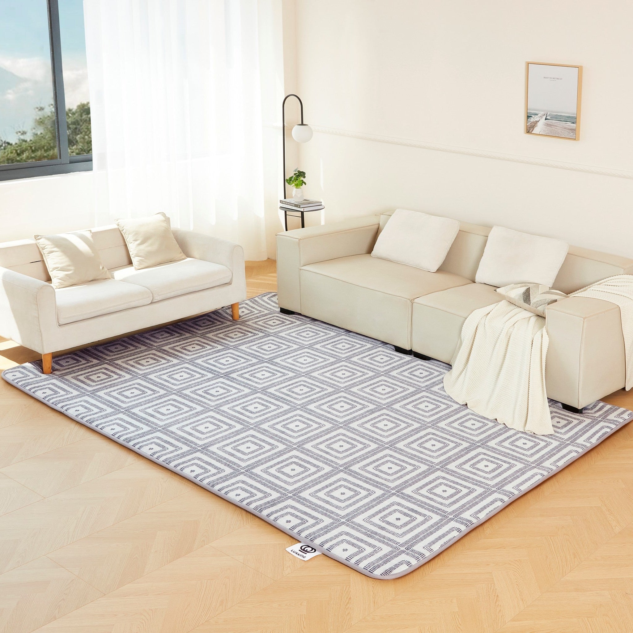 Living room with a patterned rug, beige sofa, and white walls.